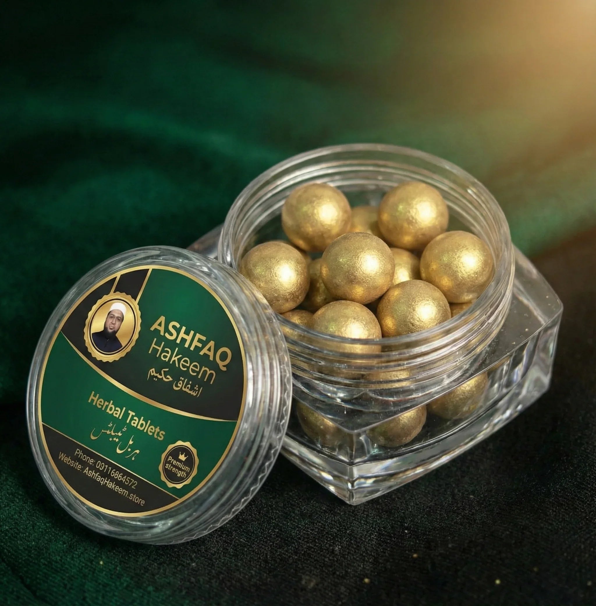 ASHFAQ Hakeem herbal tablets in a clear jar with gold-coated balls on a dark green fabric
